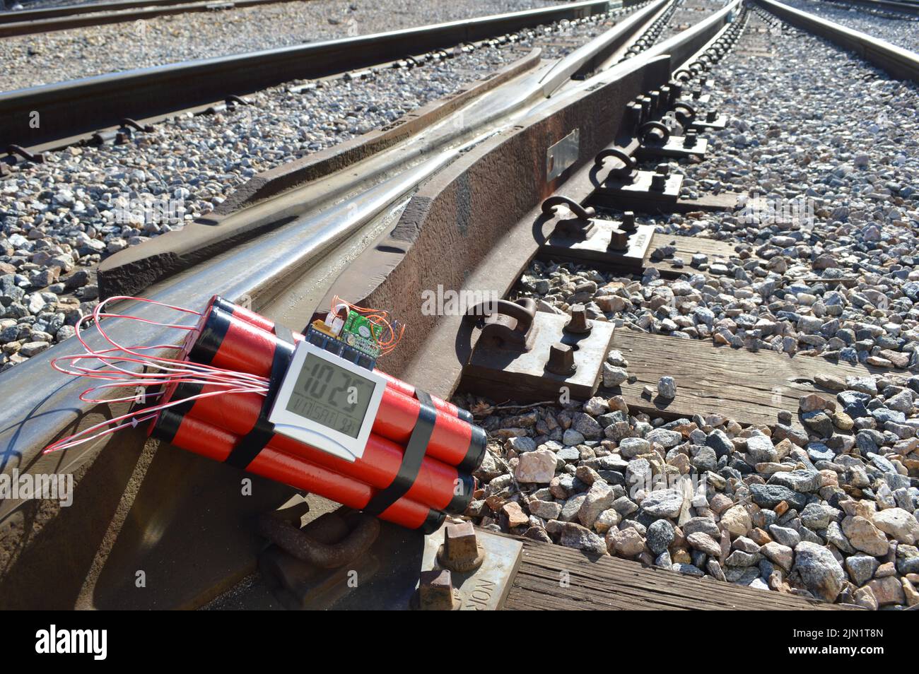 Time bomb made of dynamite, on railroad tracks Stock Photo