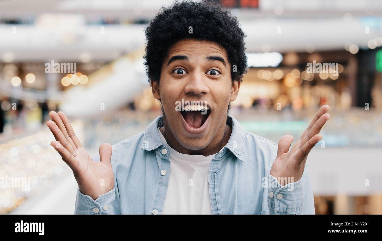 Male portrait emotions enthusiastic surprised shocked amazed man african american guy teenager looking at camera opens mouth and eyes in surprise Stock Photo