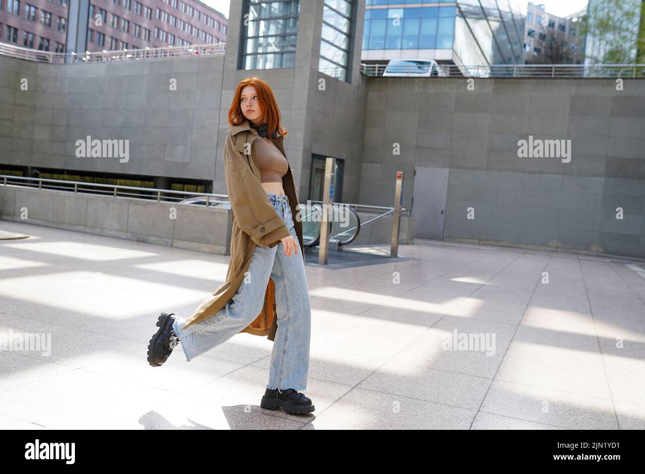 Cool teen stylish redhead hipster girl model walking in big city subway. Stock Photo