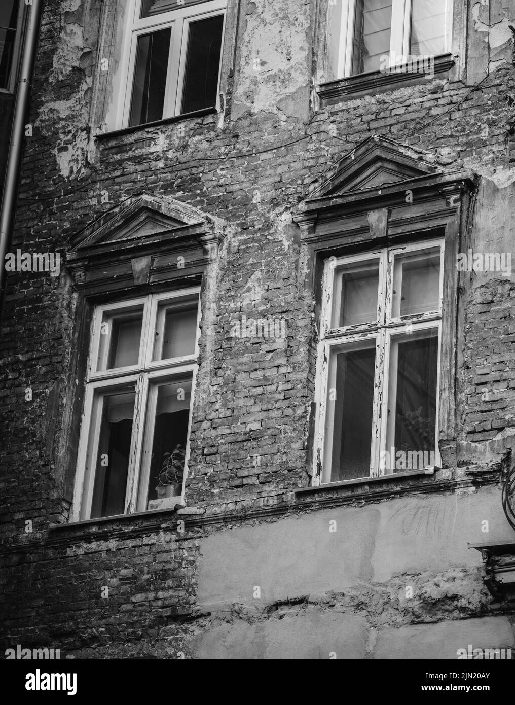 A grayscale of an ancient weathered building with old windows Stock ...