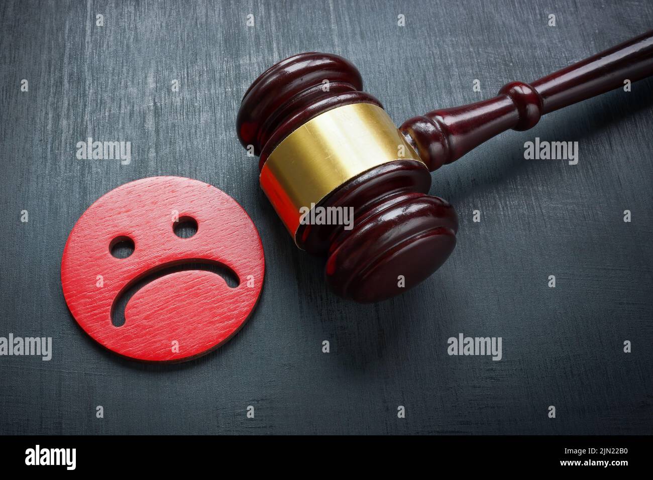 Unhappy smiley and gavel. Discrimination and Bullying law concept. Stock Photo