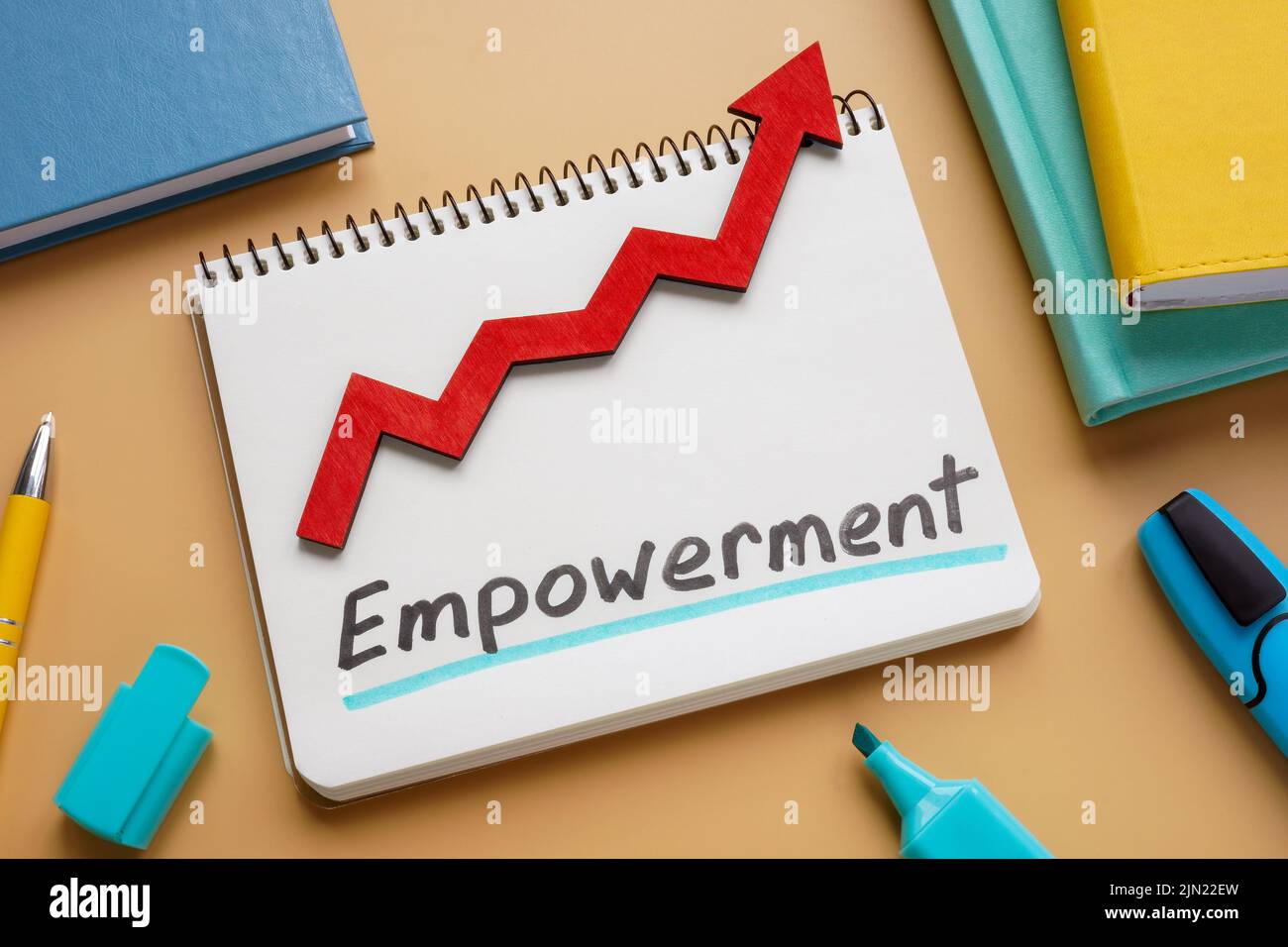 Handwritten word Empowerment and rising arrow on the notepad. Stock Photo