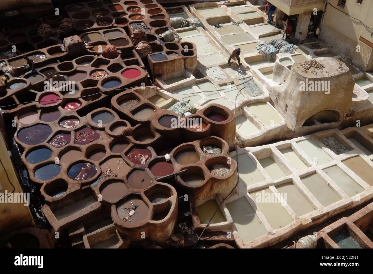 Leather dying in a traditional tannery. Old containers of the Fez's tanneries with colour paint for leather, Tanneries of Fes, Morocco, Africa. Stock Photo