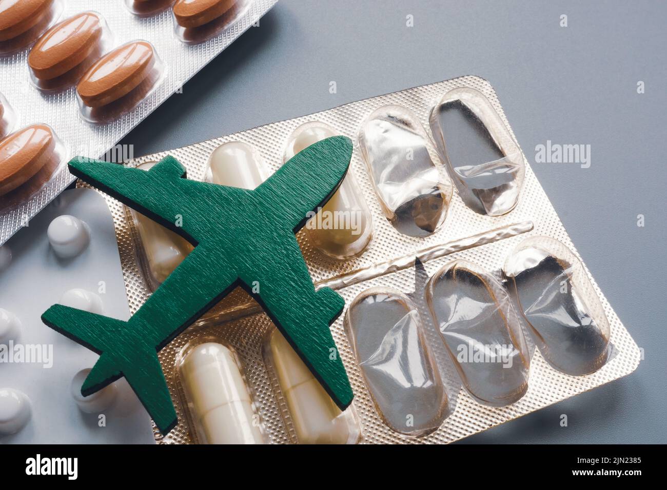 The figurine of the plane lies on the pills. Travel and medicine. Stock Photo