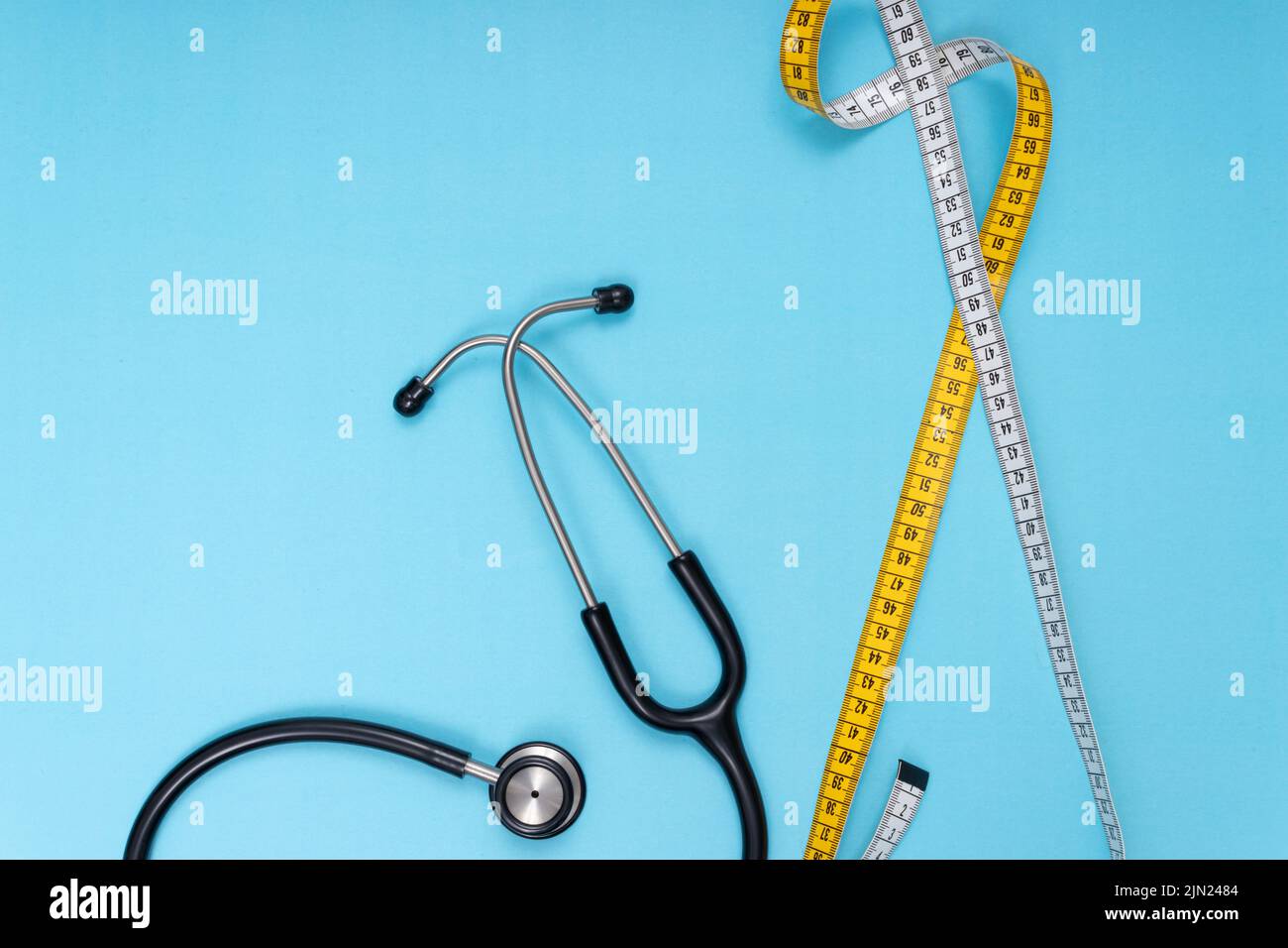 black stethoscope, tape measure, blue isolated background Stock Photo Alamy