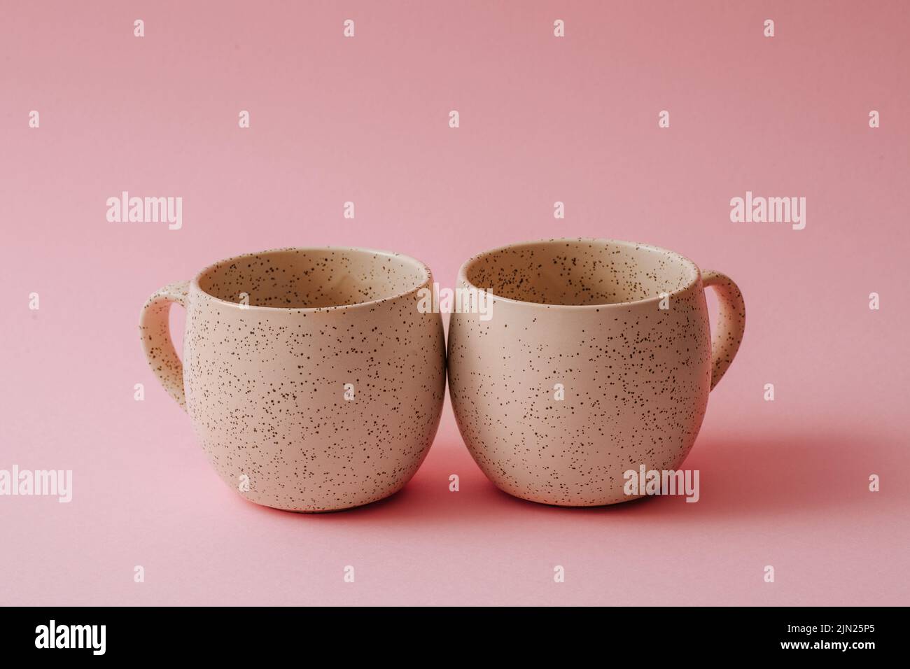 Two porcelain empty cups on a pink background, copy space Stock Photo