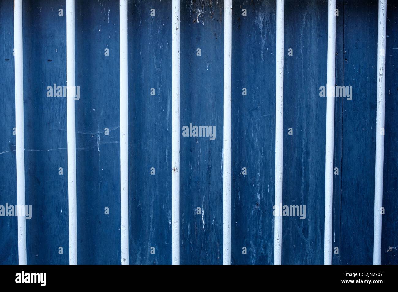 Dorking, Surrey Hills, London UK, July 07 2022, White Painted Security Bars Against A Blue Wooden Background With No People Stock Photo