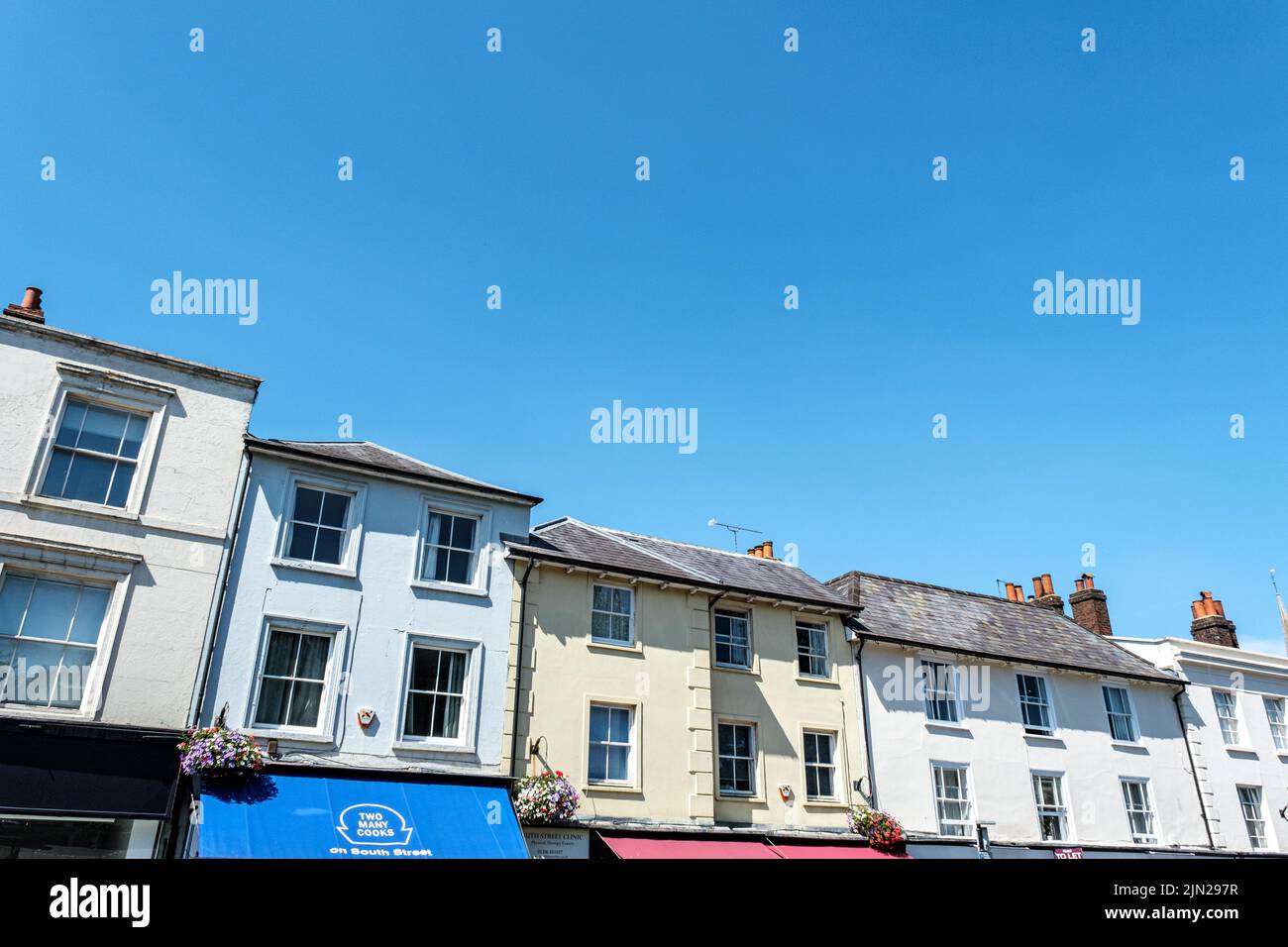 Dorking, Surrey Hills, London UK, July 07 2022, A Row Or Line Of Traditional Town Centre Residential Buildings Against A Blue Sky Stock Photo