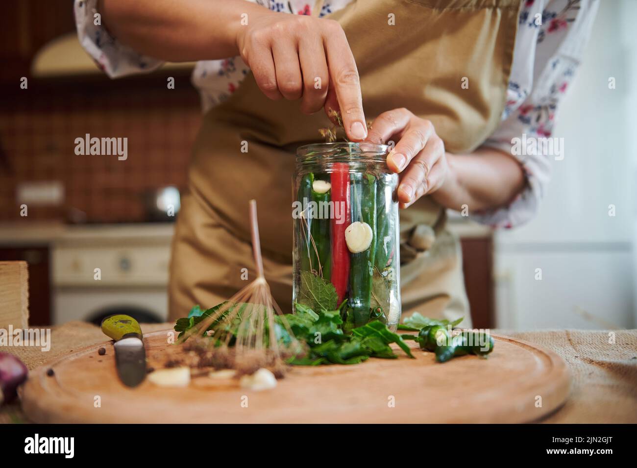 putting peeled fresh garlic in the glass jar with fresh chili peppers