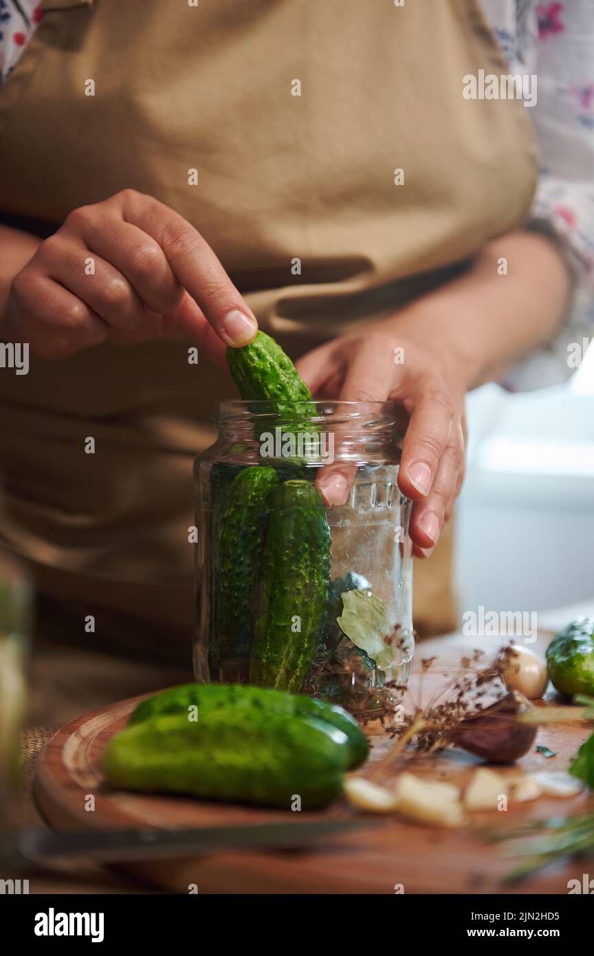 Cropped view of a woman pickling cucumbers by natural fermentation
