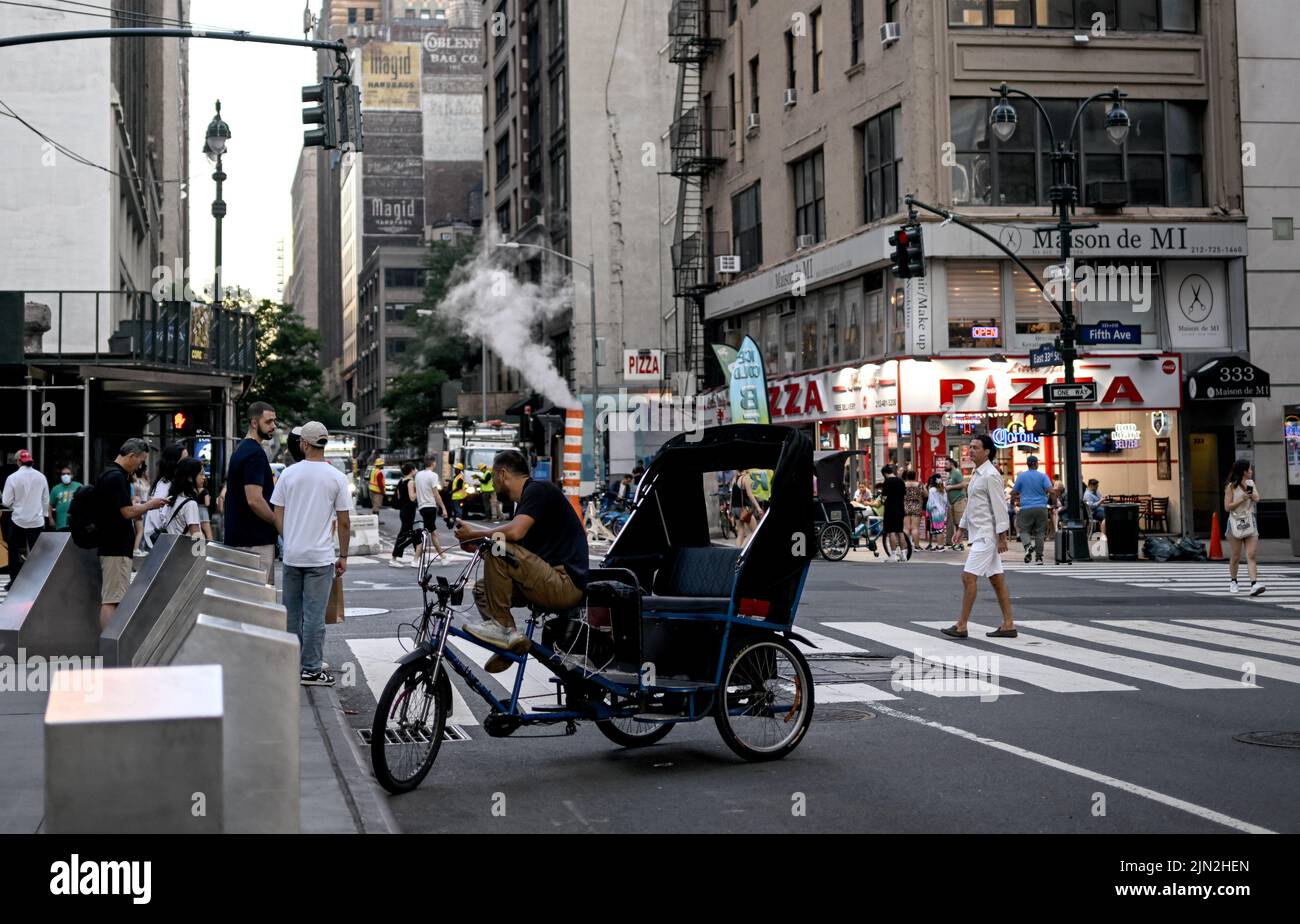 New York, USA. 02nd Aug, 2022. A man waits for customers in a bicycle rickshaw in the Manhattan borough. Credit: Britta Pedersen/dpa/Alamy Live News Stock Photo