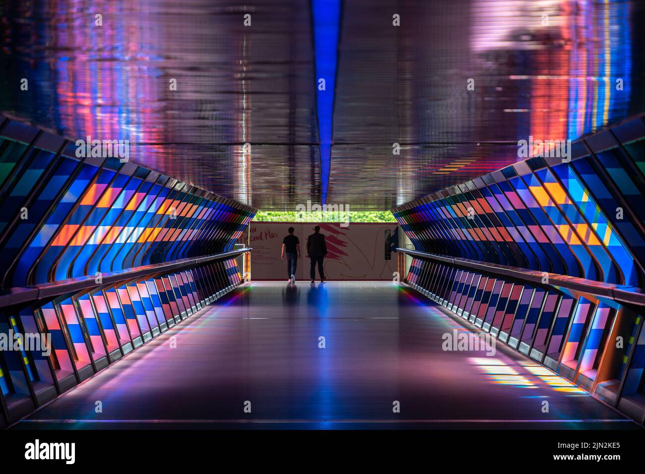 London, UK - 10 June 2022: The colorful Crossrail Place footbridge with walking people in the distance on Canada Square, Canary Wharf, London Stock Photo