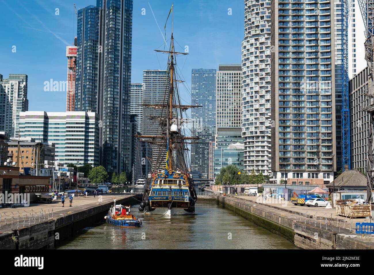 18th century replica tall ship Gotheborg in lock to South Dock, Canary Wharf, before mooring at Thames Quay, surrounded by tall Docklands buildings. Stock Photo