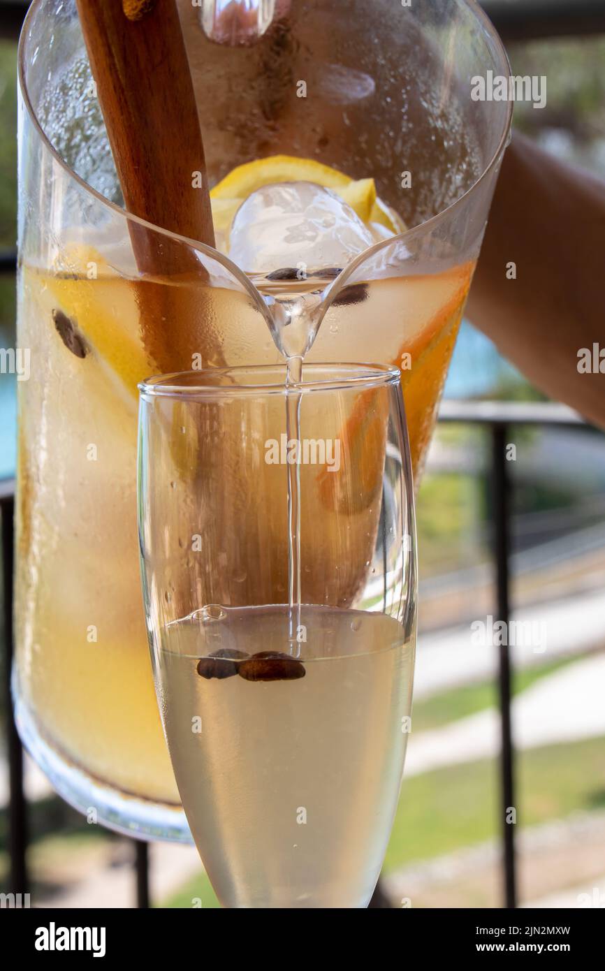 https://c8.alamy.com/comp/2JN2MXW/a-person-is-pouring-cava-sangria-from-the-pitcher-into-a-glass-2JN2MXW.jpg
