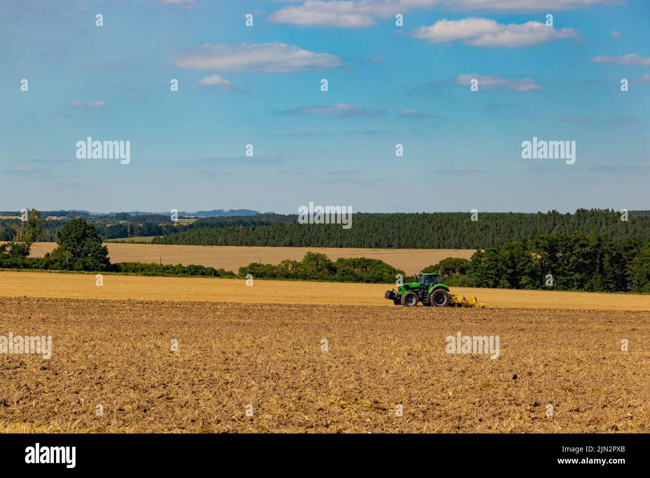 A tractor is harvesting in the field Stock Photo - Alamy