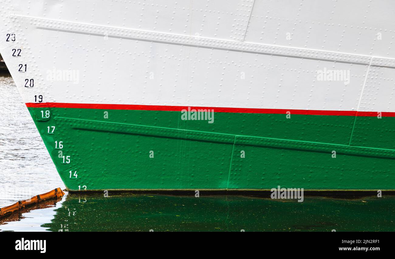Vintage white sailing yacht hull with red green waterline and draft marks Stock Photo