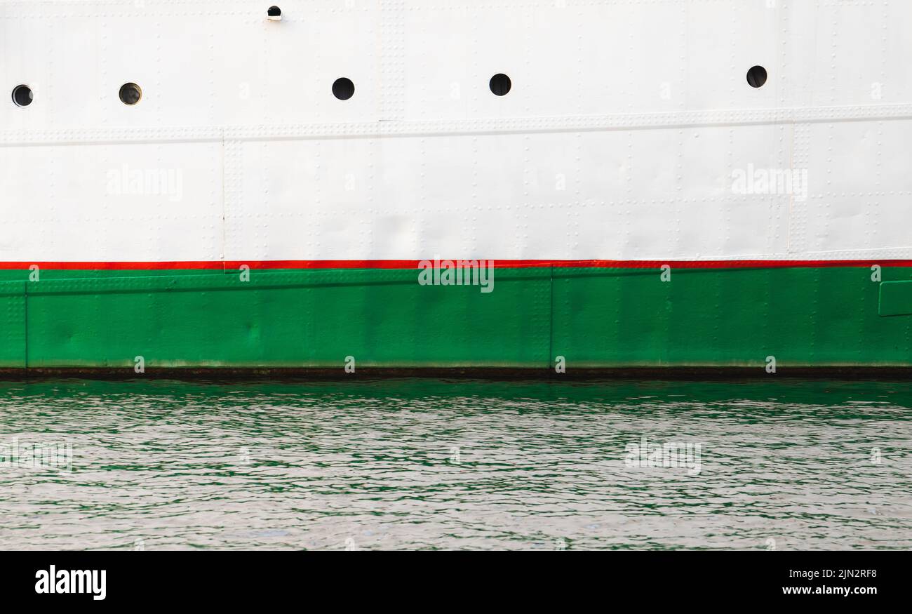 Vintage white ship hull with red green waterline and portholes Stock Photo