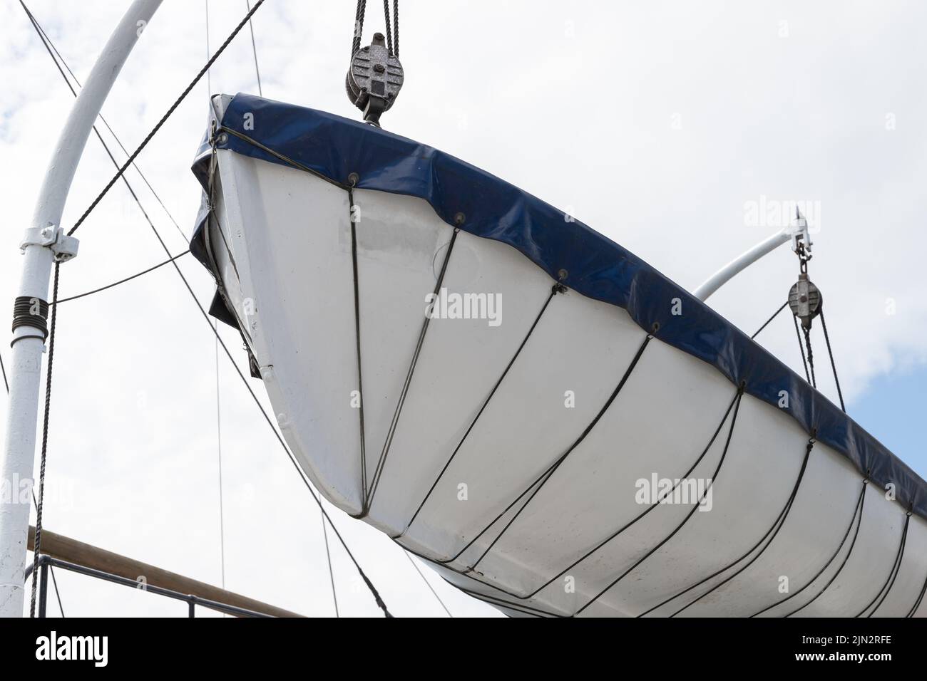 A rescue boat is on a passenger ferry above white sky background. Marine safety equipment Stock Photo
