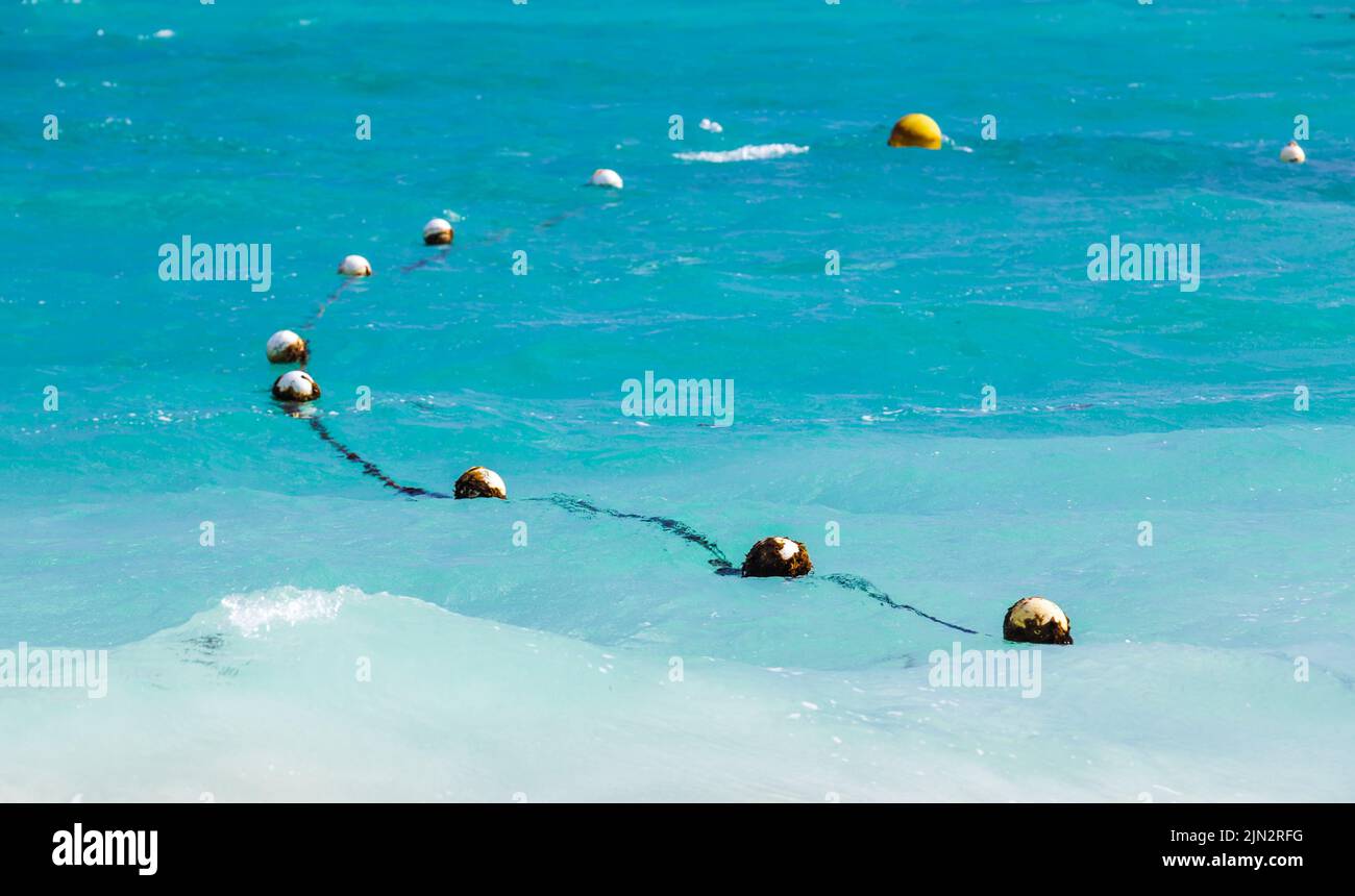 Swimming area border marked with floating yellow spheres on rope Stock Photo