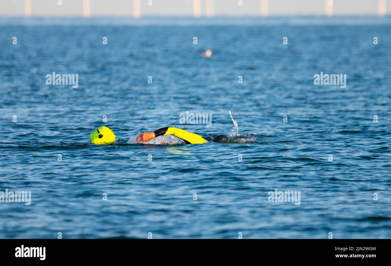 Littlehampton, West Sussex, UK. Monday 8th August 2022. A swimmer cools off in the sea late this evening as the heatwave continues on the south coast. Credit: Geoff Smith/Alamy Live News Stock Photo