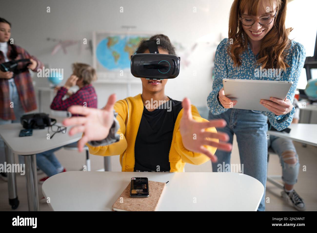 Teenage students wearing virtual reality goggles at school in computer