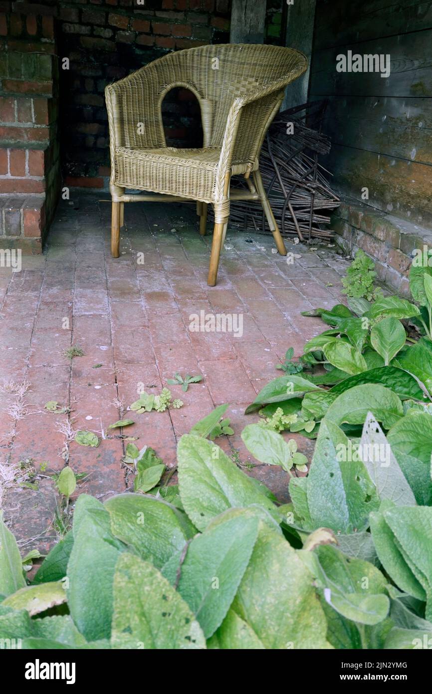 vintage wicker chair on red brick paved floor Stock Photo