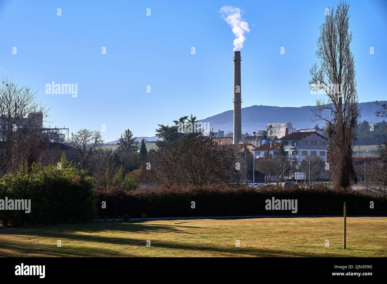 Landscape with a chimney releasing polluting gases into the air Stock Photo
