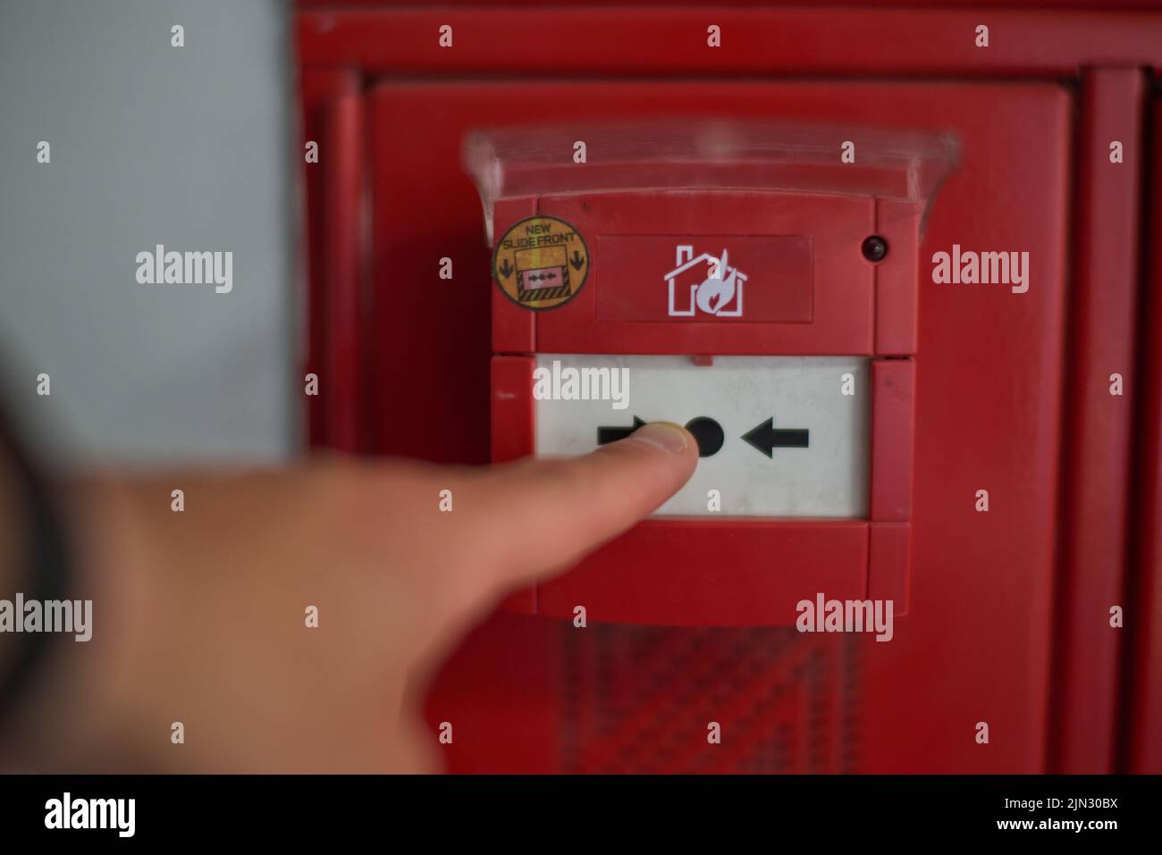 Hand pressing on the trigger of a fire alarm Stock Photo Alamy