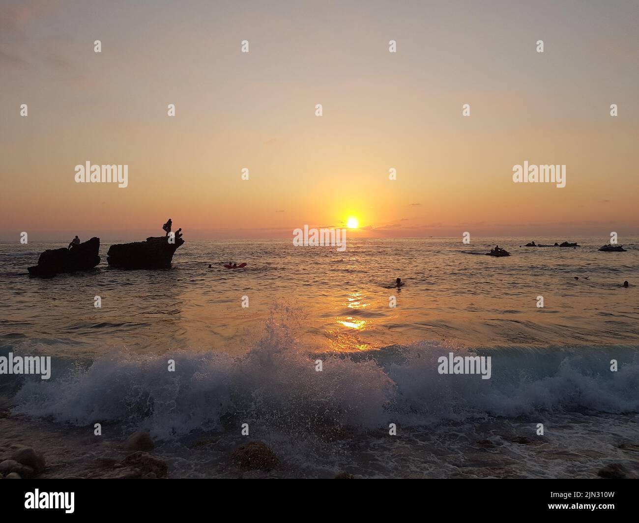 A beautiful shot of a sea with rocks and waves hitting a shore at ...