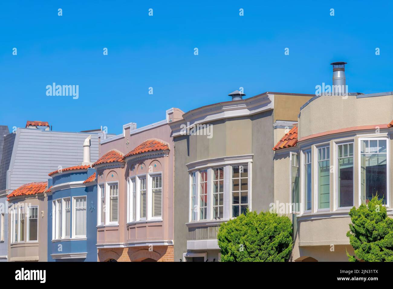 Side view of adjacent homes with curved window walls in San Franciso, California. Different front exterior of houses sash windows. Stock Photo