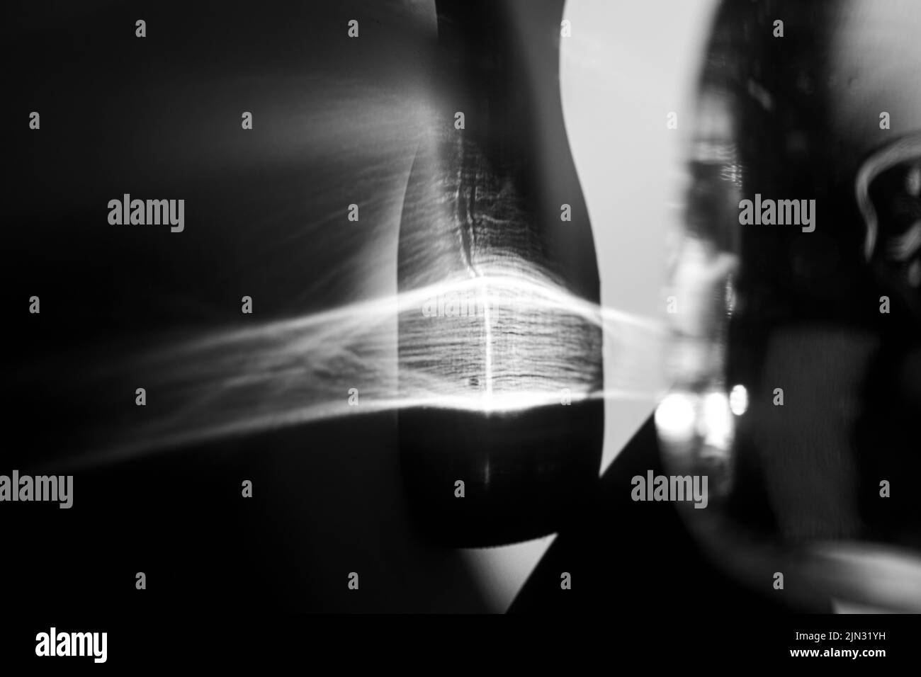 Glass bottle cast beautiful shadow and caustic effect as light passes through a glass. Black and white photo. Abstract background Stock Photo