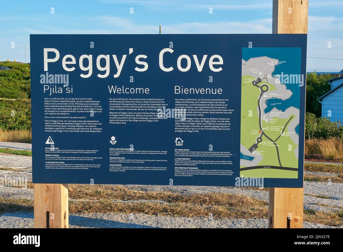 Sign welcoming vistors in three languages as you enter Peggy's Cove Nova Scotia.  The languages incluse Mi'kma'ki, English and French. Stock Photo