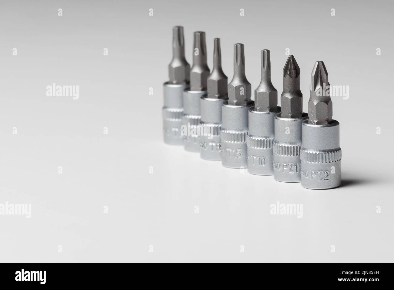 Screwdriver bits, different designs on grey background. Copy space. Close up Stock Photo