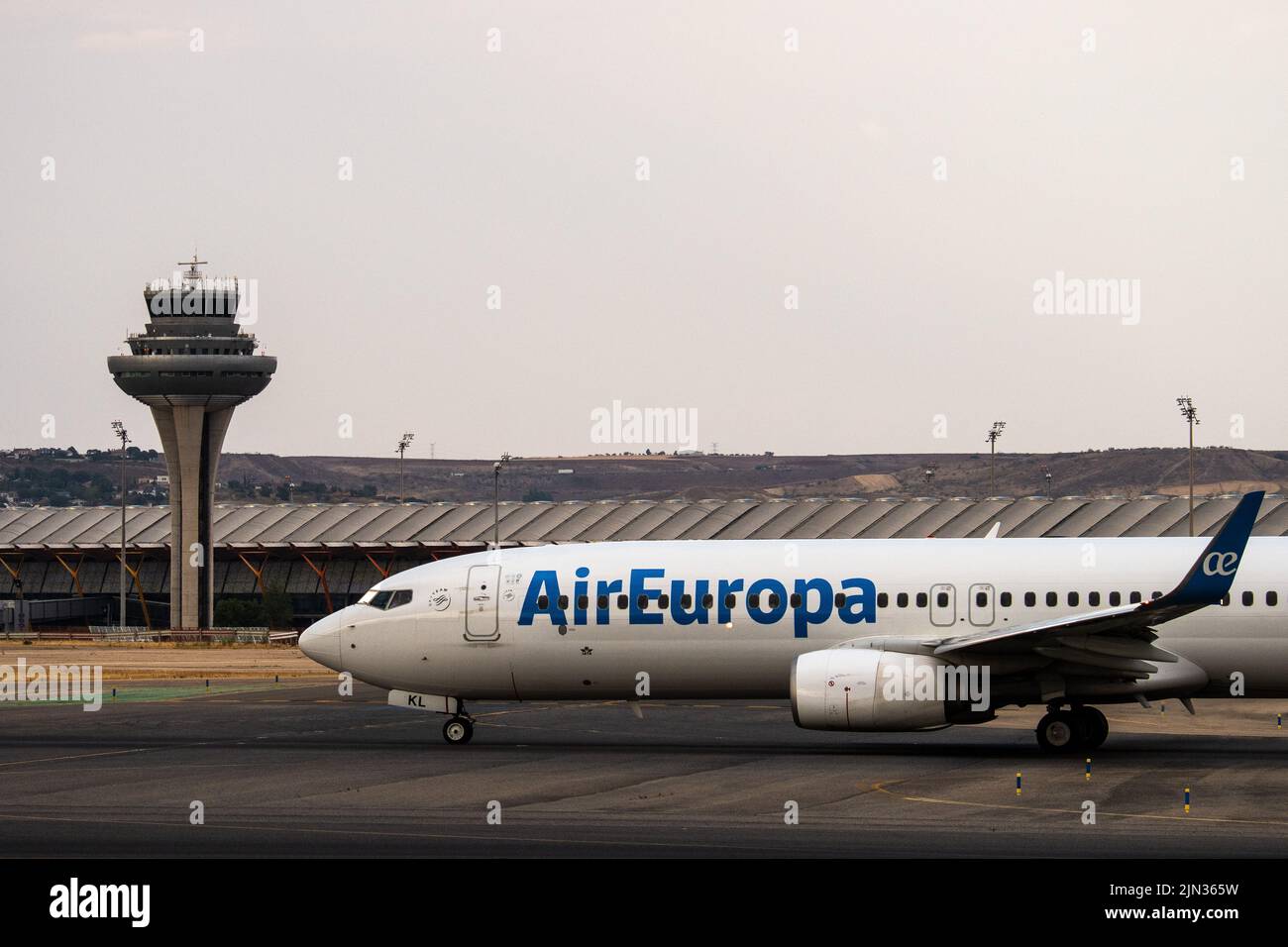An Air Europa airplane in seen on the runway at Adolfo Suarez Madrid Barajas Airport passing by the air traffic control tower. Stock Photo