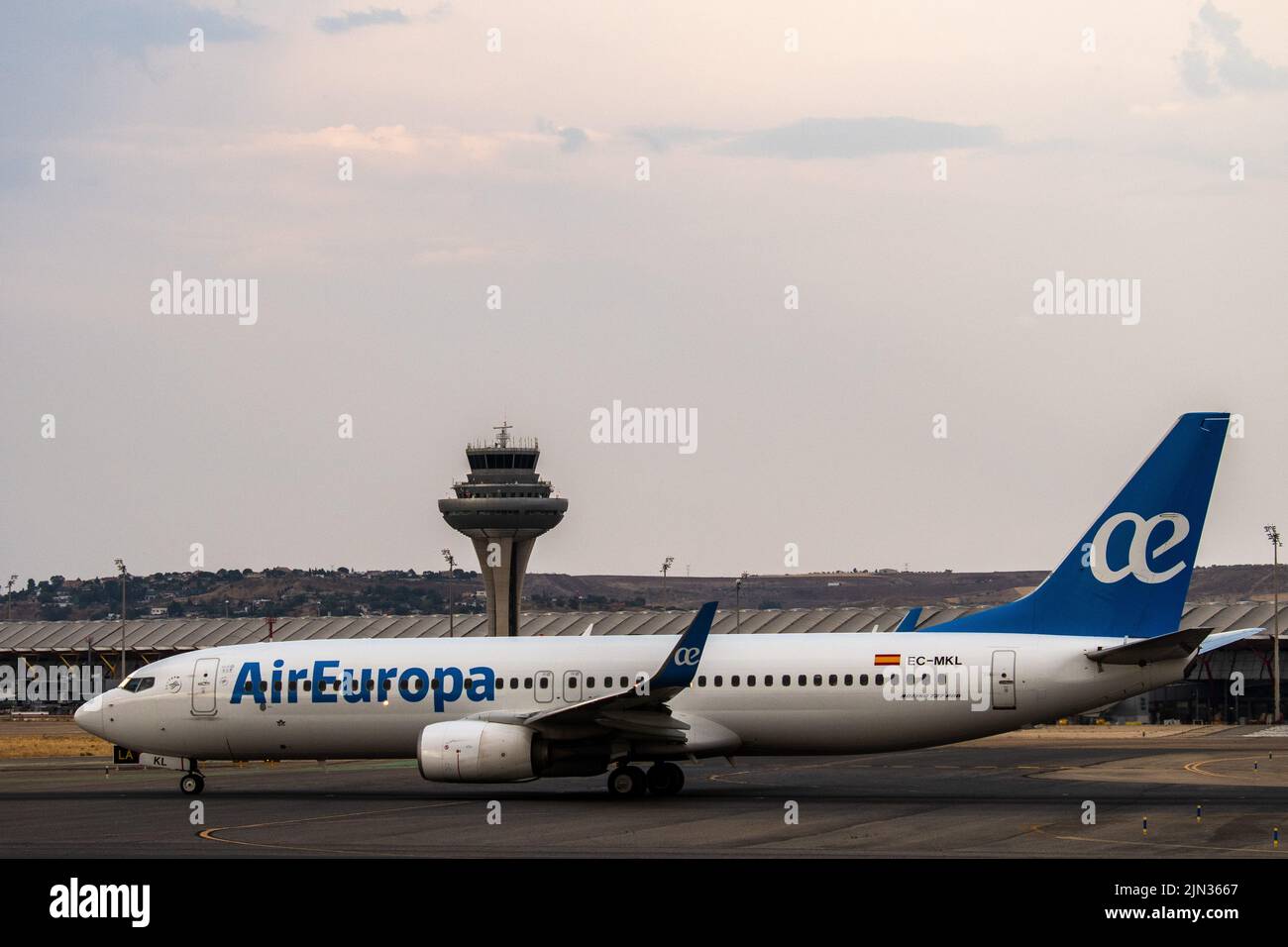 An Air Europa airplane in seen on the runway at Adolfo Suarez Madrid Barajas Airport passing by the air traffic control tower. Stock Photo