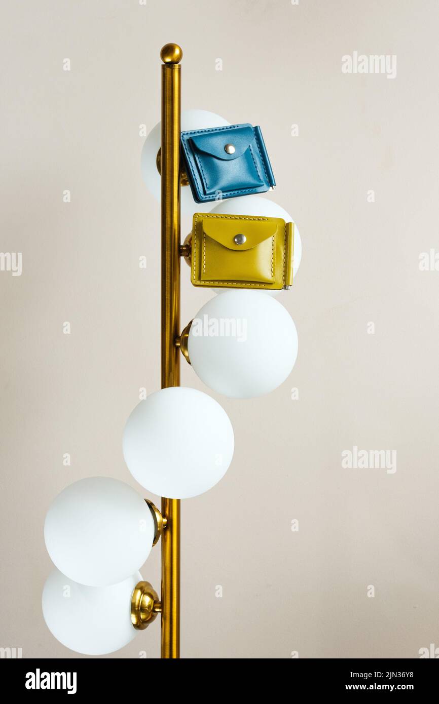 Two colored leather wallets placed on a lamp indoors Stock Photo