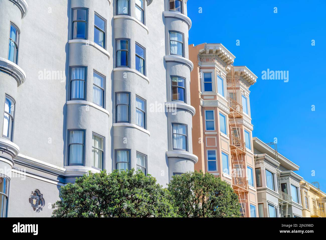 Gray apartment building along with the victorian flat apartments in San