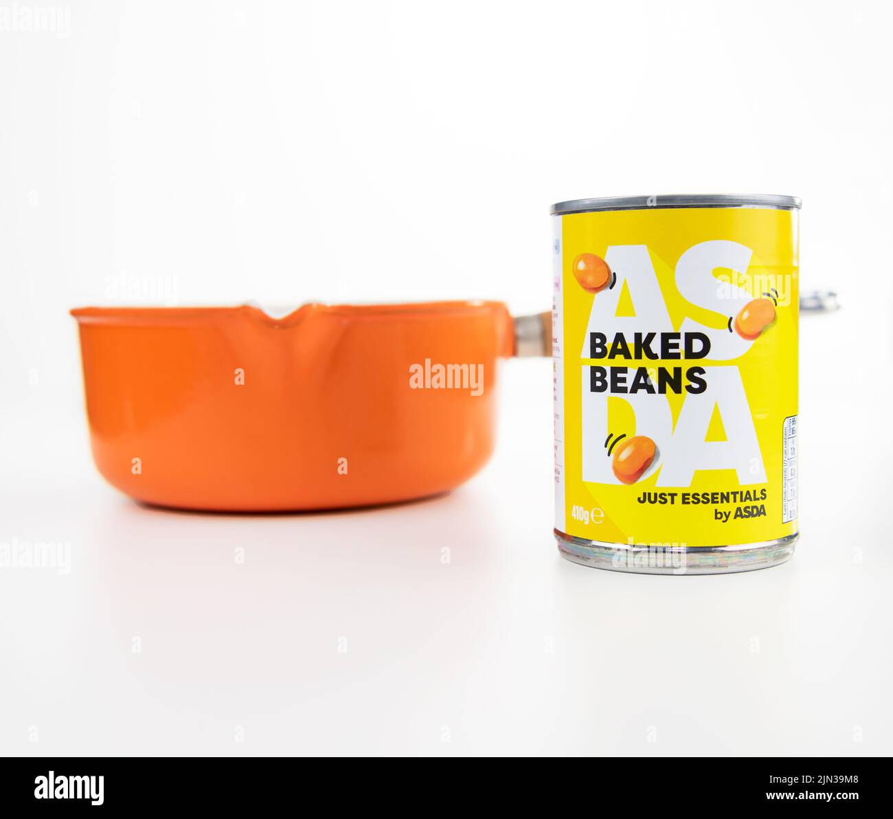 Asda Essentials Low Priced Baked Beans  with an orange Saucepan on a white background Stock Photo