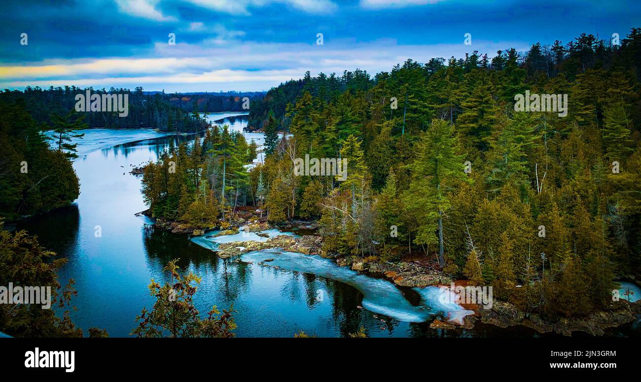 A drone shot of a beautiful lake surrounded by trees of a forest under ...