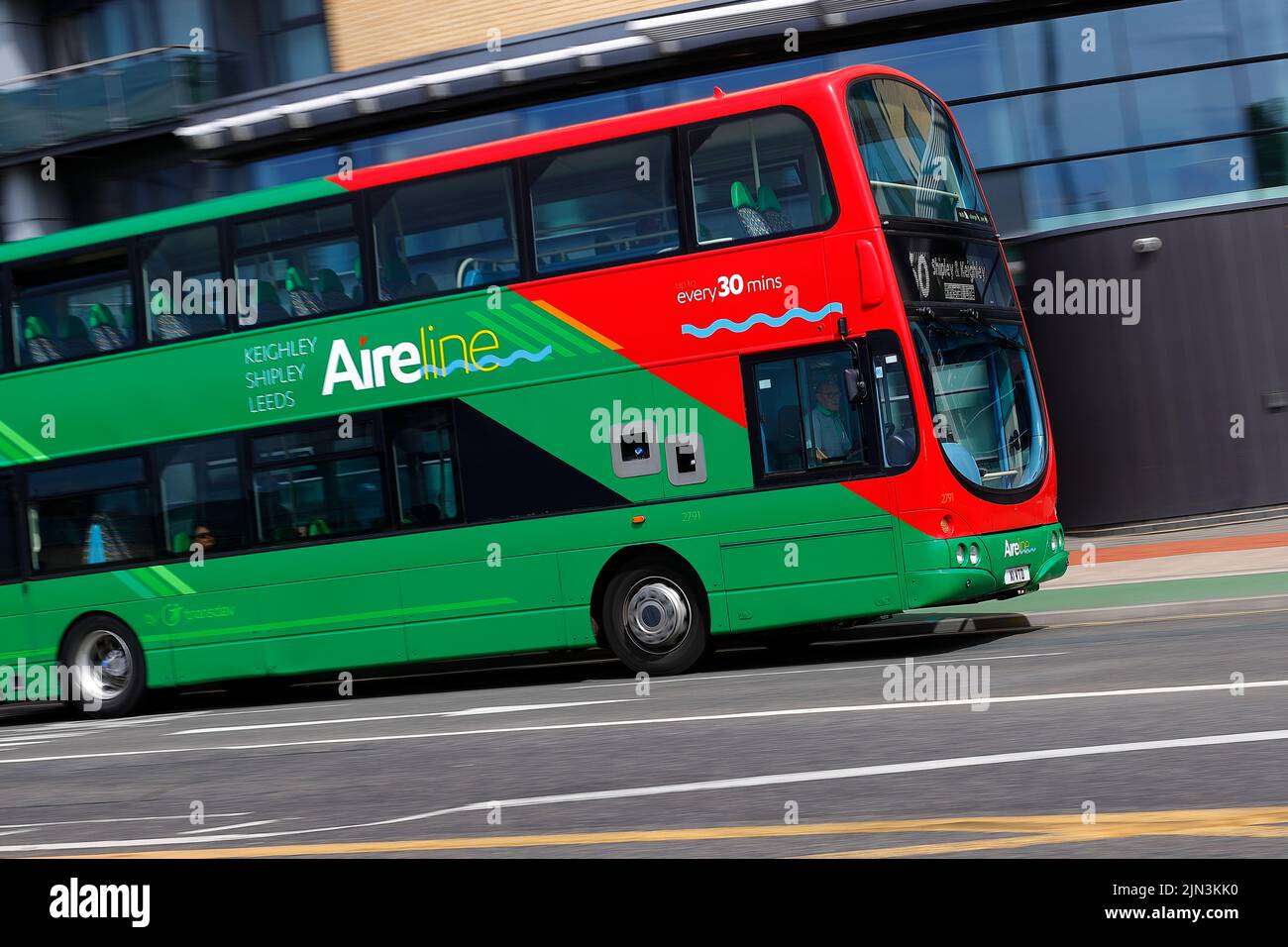 A panning shot of a moving double decker bus in Leeds City Centre  operated by The Keighley Bus Company. Stock Photo