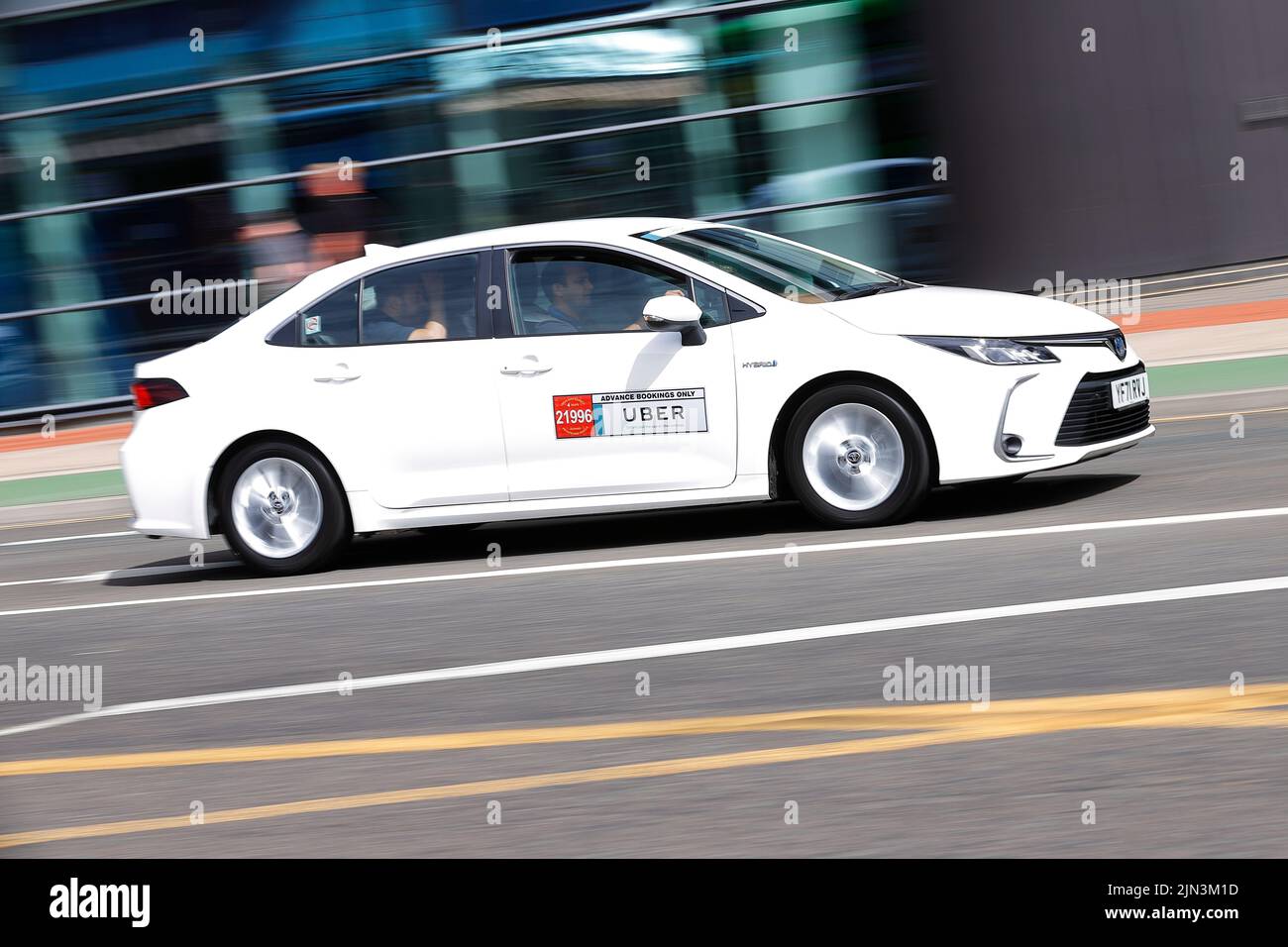 An Uber private hire cab, seen passing throug hLeeds City Centre with passengers. Stock Photo