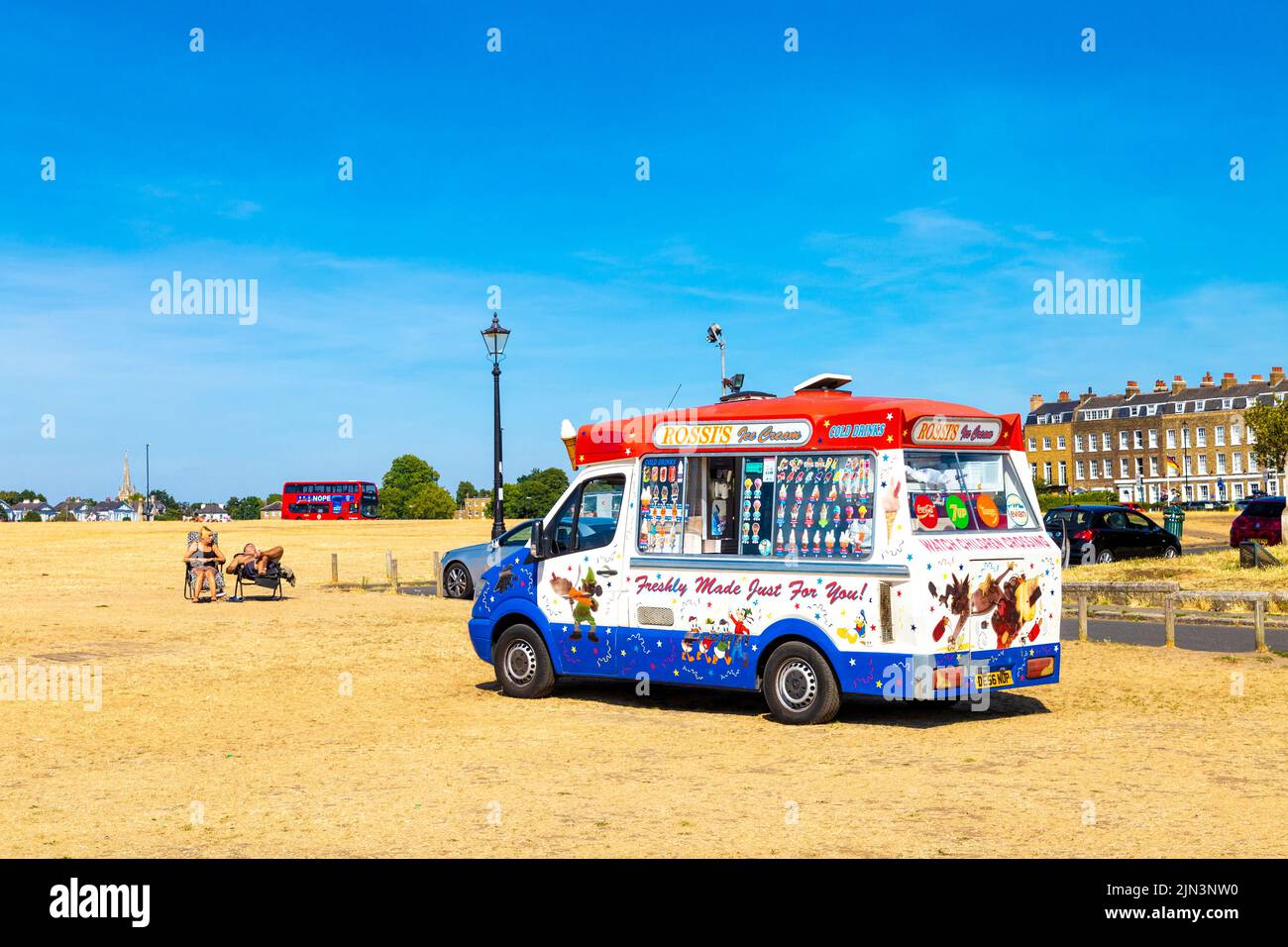 6 August 2022 - London, UK - Dried out grassland in Blackheath after a series of heatwaves and record high temperatures in the city, ice cream truck serving cold refreshments Stock Photo