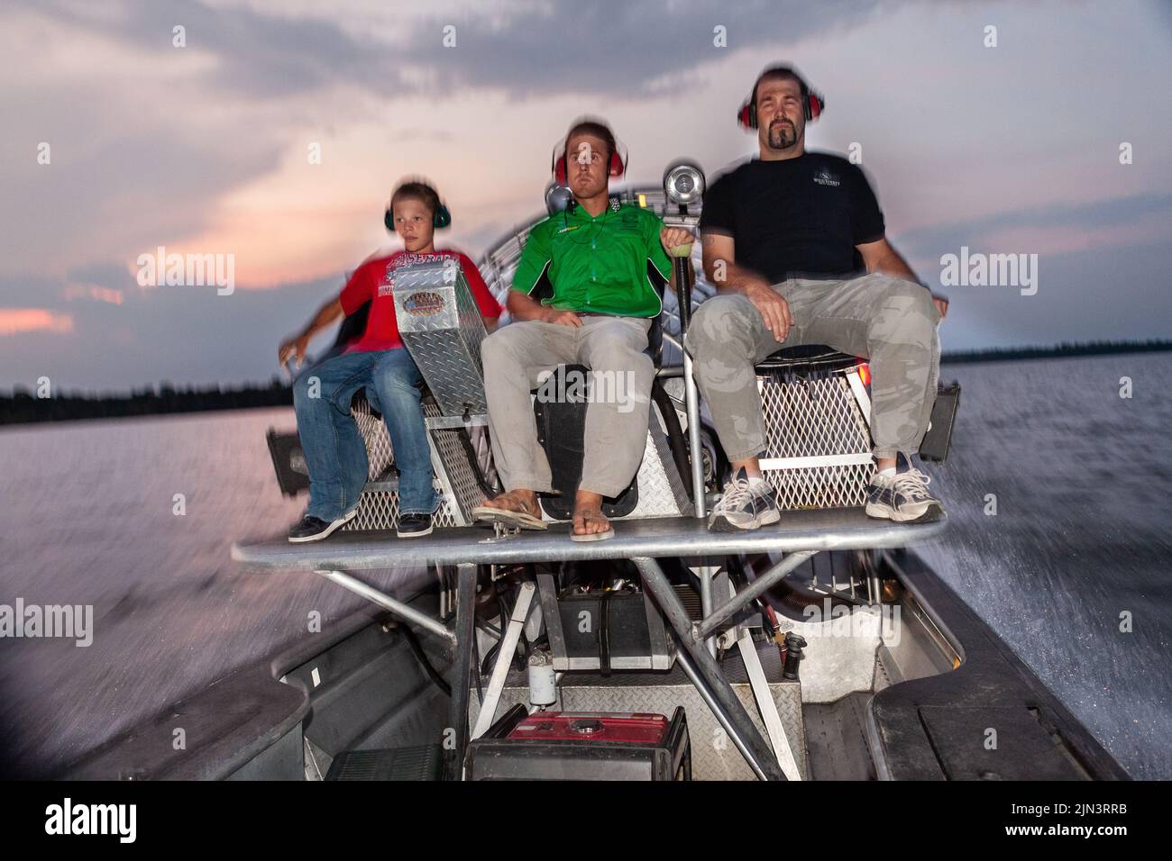 An alligator hunting guide takes his clients out on an airboat for a nighttime alligator hunting expedition in Bowman, South Carolina. Alligator hunting in South Carolina is limited by lottery and a four-week season once a year. Stock Photo