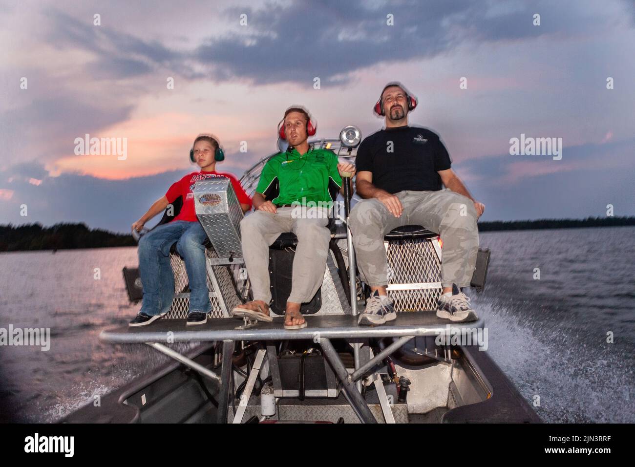 An alligator hunting guide takes his clients out on an airboat for a