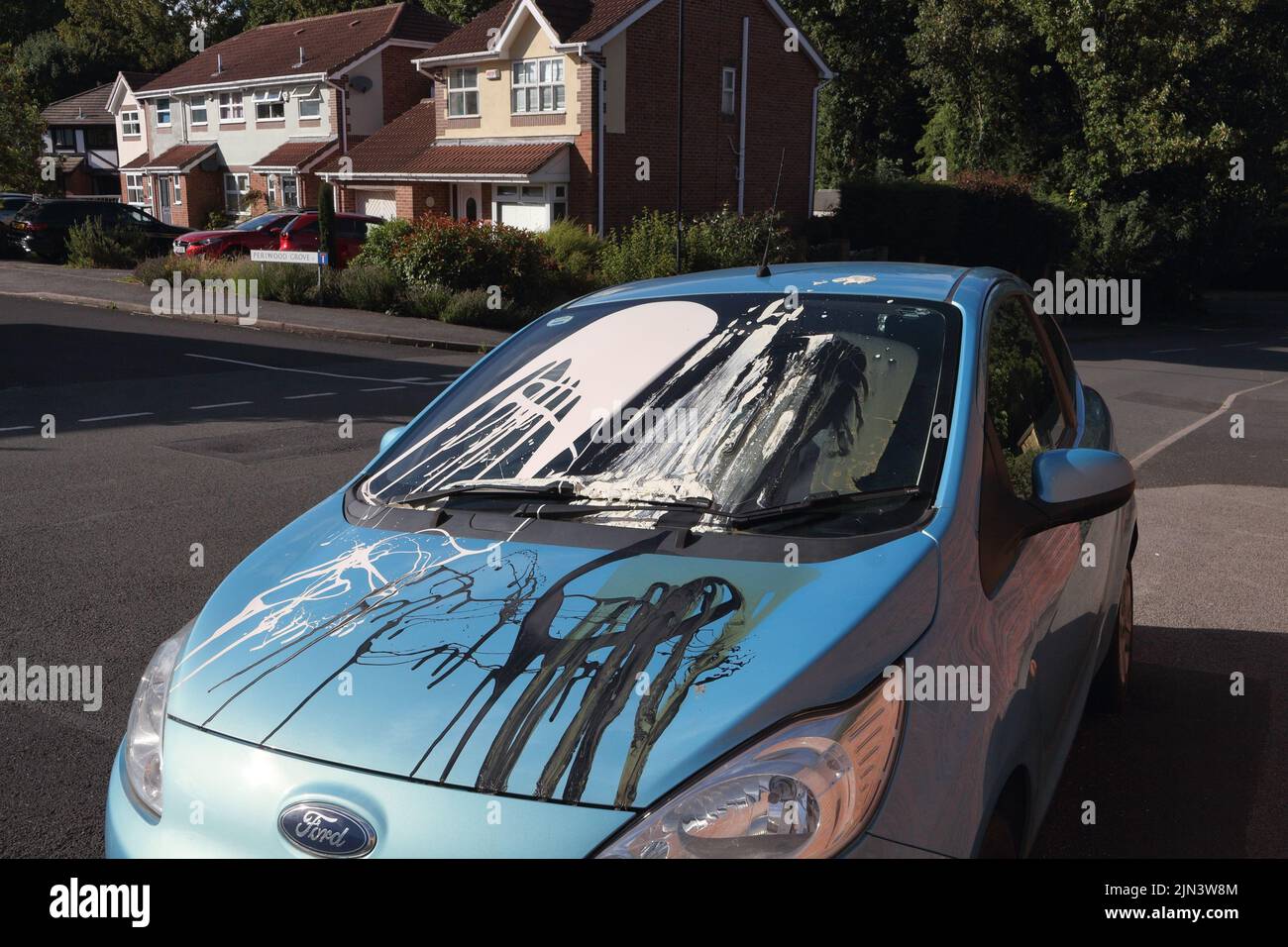 Car vandalised with paint thrown all over the windscreen and bonnet damaged. In England. A vandalised car vehicle Stock Photo