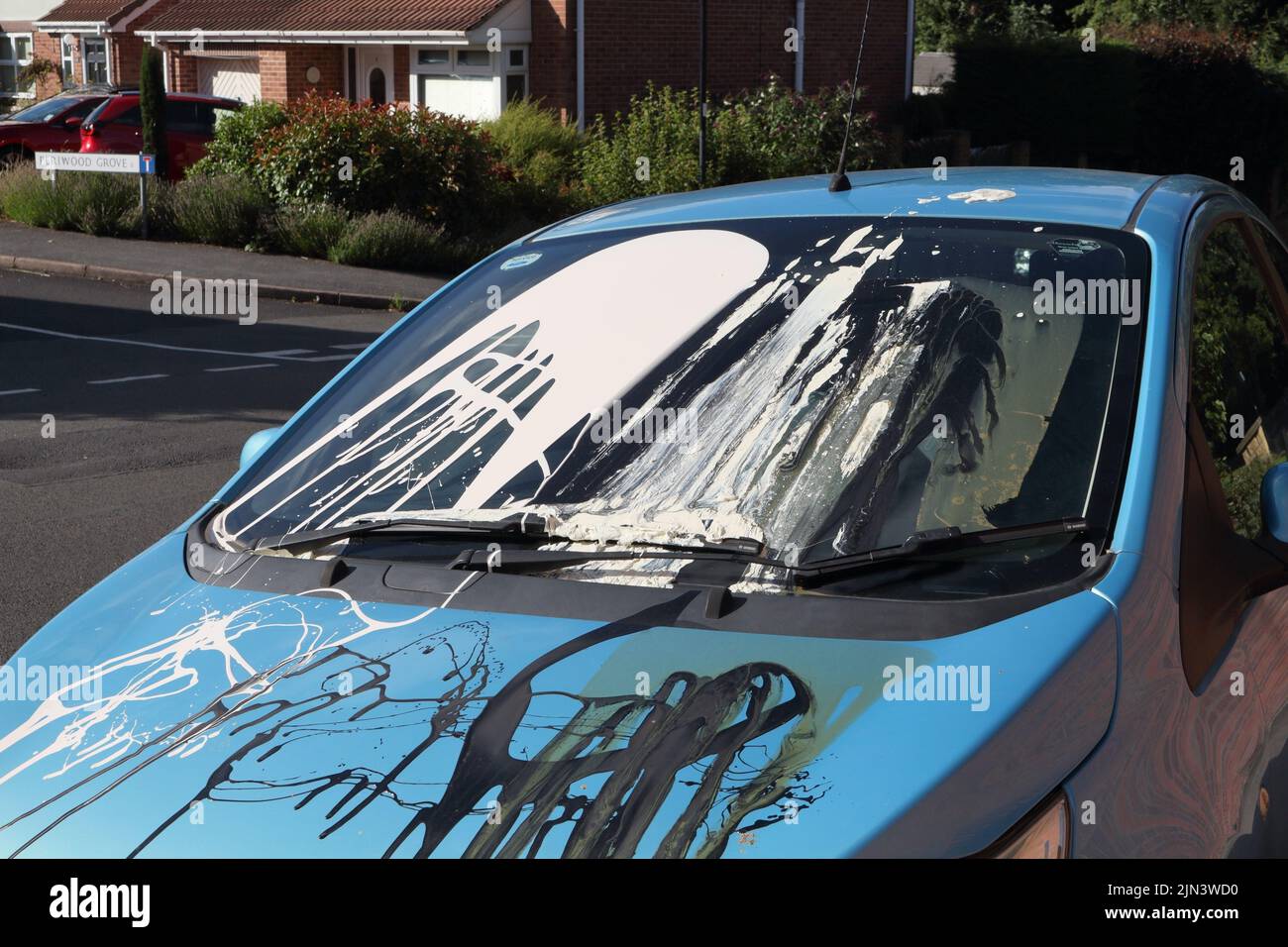Car vandalised with paint thrown all over the windscreen and bonnet damaged. In England. A vandalised car vehicle Stock Photo
