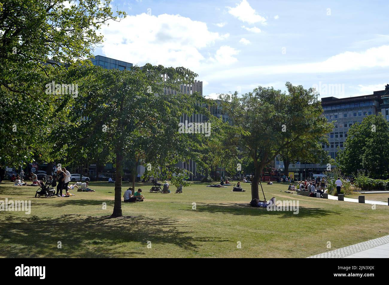 EDINBURGH, SCOTLAND - 1 AUGUST 2022: People relax in summer sunshine in St Andrew Square. Stock Photo