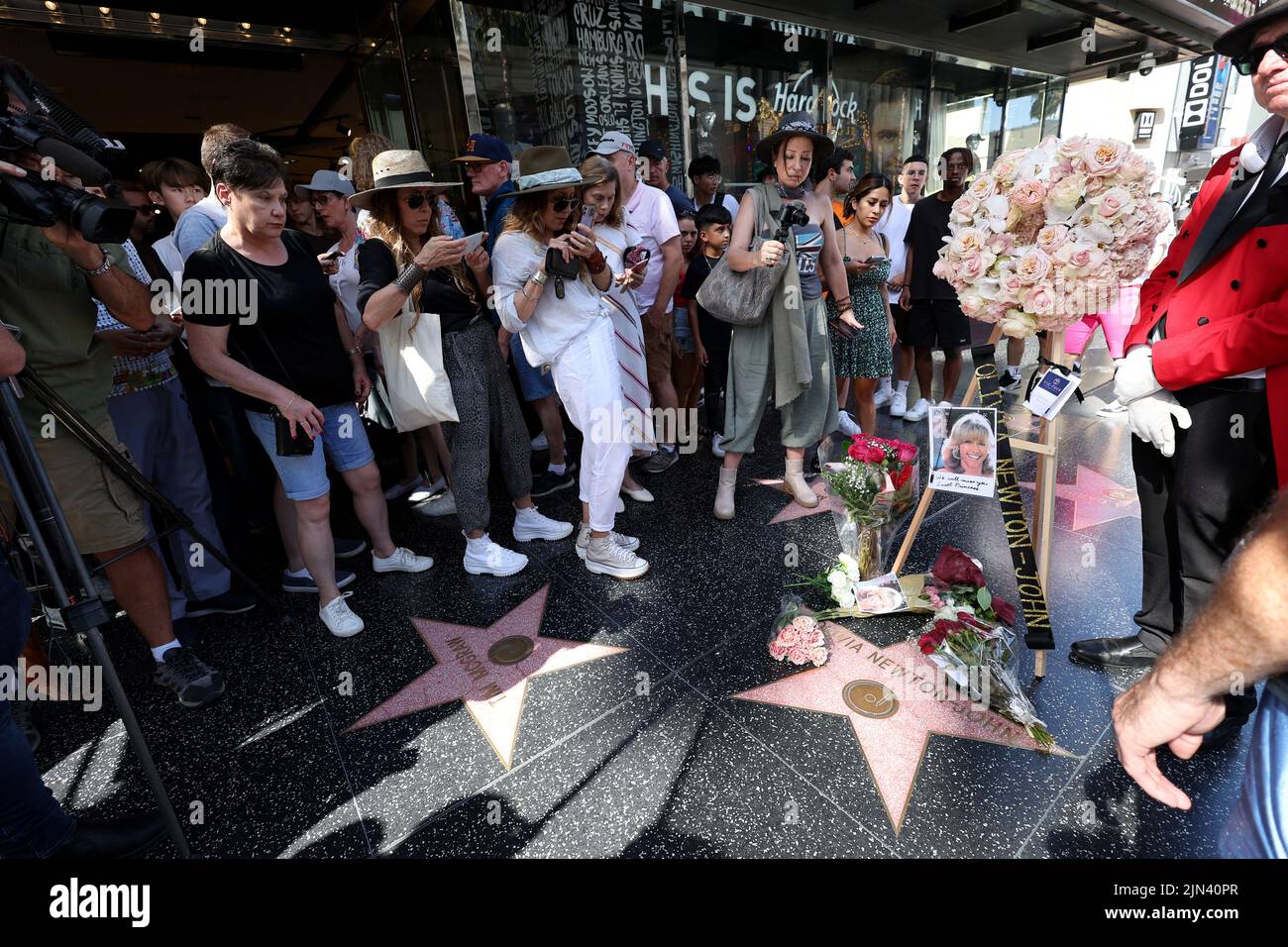 People stop by the star of late actor Olivia Newton-John which is adorned with flowers and photographs on the Hollywood Walk of Fame in Los Angeles, California, U.S., August 8, 2022. REUTERS/Mario Anzuoni Stock Photo