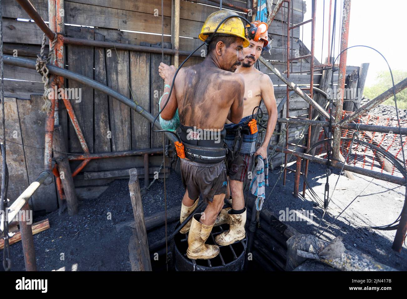 Miners descend into an artisanal coal mine, or 'pocito' (little hole), known for their rudimentary and often dangerous mining techniques, in Sabinas, Coahuila state, Mexico, August 8, 2022. REUTERS/Luis Cortes Stock Photo