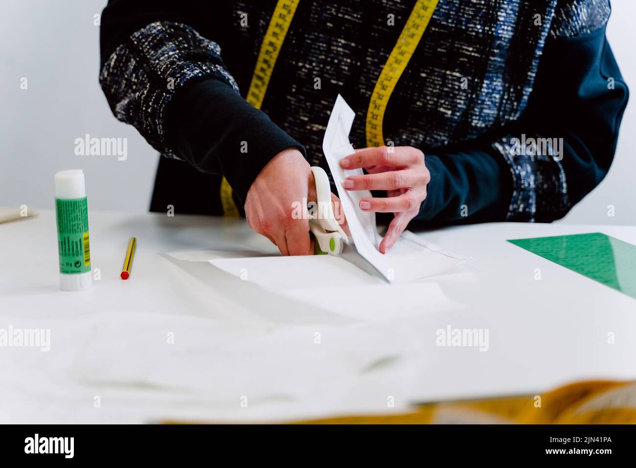 Dressmaker with scissors cutting cloth Stock Photo Alamy